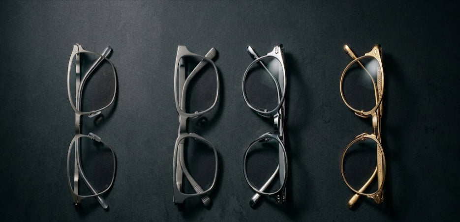 Four eyeglass frame materials side by side — titanium, Al-Mg alloy, stainless steel and standard alloy on dark background