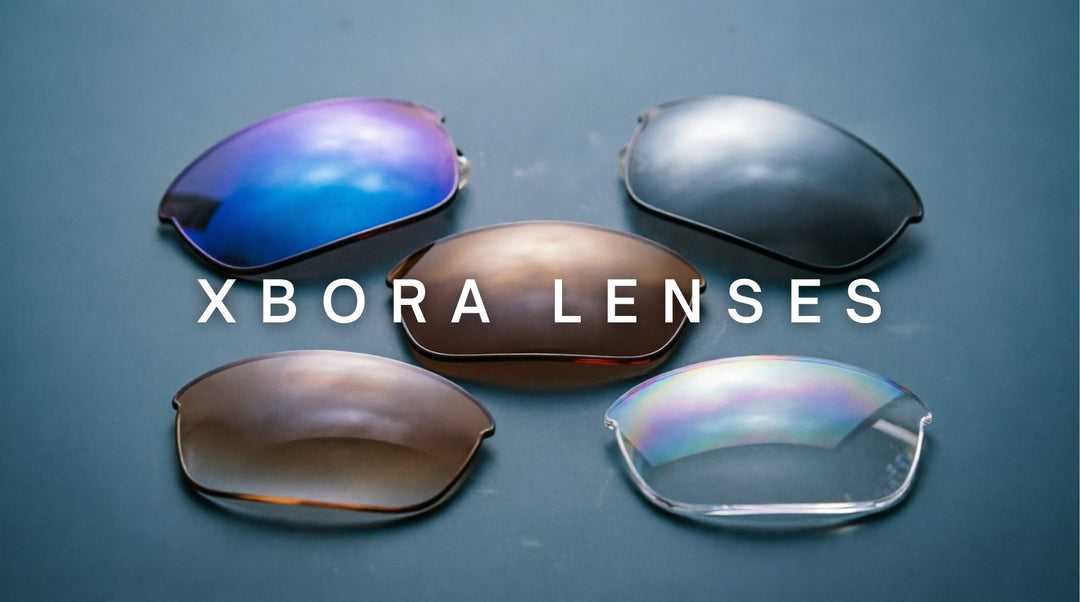 FuzWeb Xbora lenses collection featuring anti-blue light photochromic polarized progressive high-index lenses on navy-blue gray studio background with soft diffused lighting