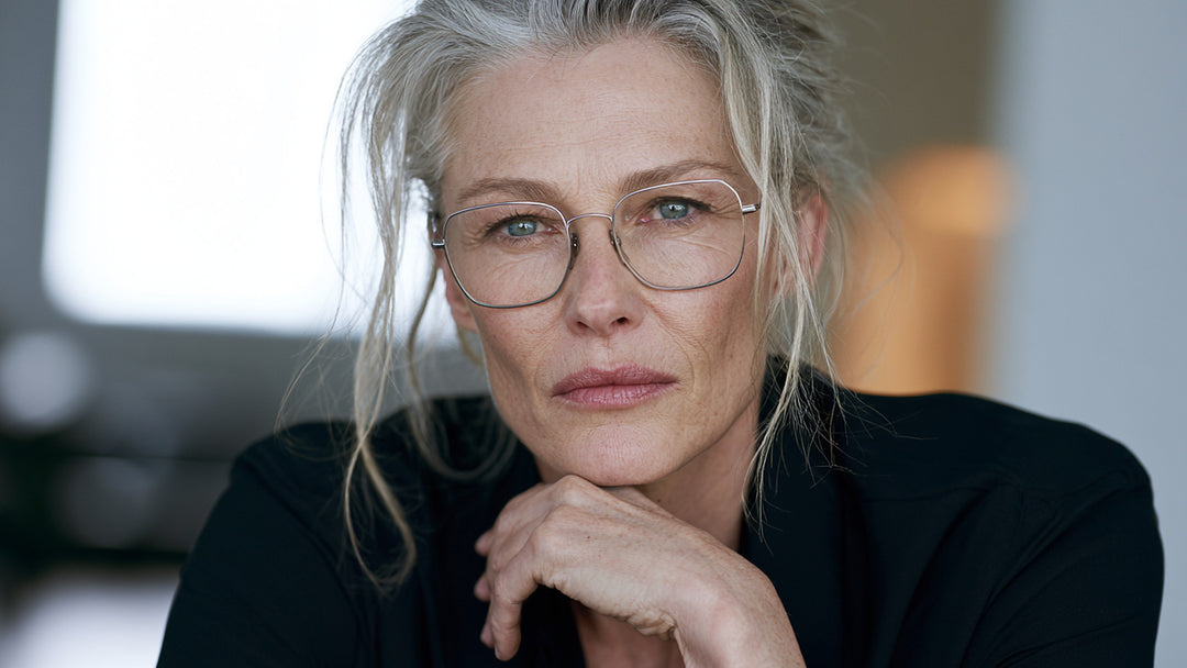Woman with grey hair wearing thin metal prescription eyeglasses